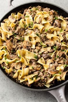 a skillet filled with pasta and meat