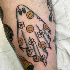 a person with a tattoo on their leg that has smiley faces and flowers in the shape of a rocket ship