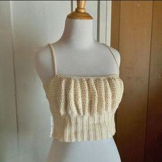 a white mannequin wearing a knitted crop top