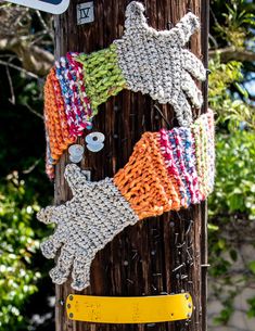 there are knitted gloves hanging on the telephone pole