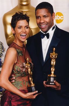 a man and woman posing with their oscars for best supporting actress in a motion