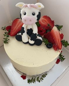 there is a cake decorated with a cow and strawberries