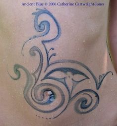 the back of a woman's stomach with blue swirls on it