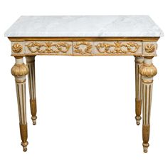 a white marble topped table with gold trimmings and carvings on the top, against a white background