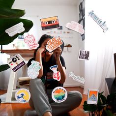 a woman sitting on the floor surrounded by stickers