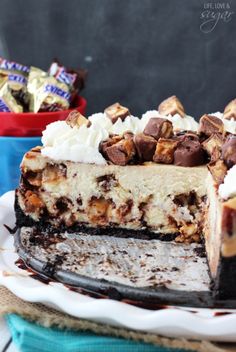 a piece of cheesecake on a plate with chocolate and marshmallows in the background