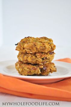 three oatmeal cookies stacked on top of each other in front of an orange napkin