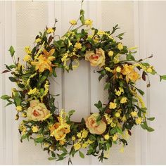 a wreath with yellow flowers hanging on a door