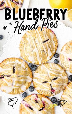 blueberry hand pies on a white plate with lemons and blueberries in the background