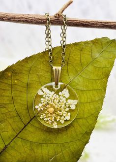 This beautiful floral mustard seed necklace is perfect for any occasion!  Share your faith and your love of nature everywhere you go. This beautiful handmade resin necklace makes the perfect gift for a loved one, a best friend, or just a reminder of your own inner beauty and faith.  Necklace is handmade with resin, real flowers, mustard seeds, and an antique bronze chain.  Chain Length: 18 inches long  Chain Width: 1.5 mm Antique Bronze chain with lobster clasp Please contact me if you have any questions or requests. Due to the handmade nature of the resin process no two necklaces will ever be exactly identical. Please keep in mind that there may be some minor imperfections in the resin, such as tiny air bubbles SHOP DESCRIPTION: Resin jewelry has endless possibilities and I love creating Nature-inspired Gold Resin Jewelry, Gold Resin Nature-inspired Jewelry, Delicate Yellow Necklace For Gift, Botanical Style Gold Resin Jewelry, Resin Necklace With Flower Pendant For Birth Flower, Spiritual Style Necklace With Pressed Flowers As A Gift, Spiritual Necklaces With Pressed Flowers As Gift, Resin Birth Flower Pendant Necklace, Gold Nature-inspired Flower Necklace For Gift