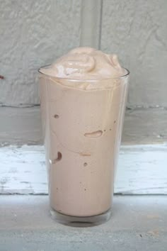 a drink in a glass sitting on the side of a window sill next to a door