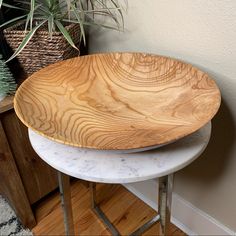 two wooden trays sitting on top of each other next to a potted plant