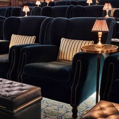 rows of black velvet chairs and footstools with lamps on them