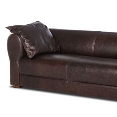 a brown leather couch with two pillows on it's back and one arm facing the camera