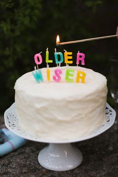 a birthday cake with candles that say older wiser