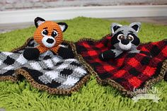 two crocheted stuffed animals laying on top of a green rug covered in grass