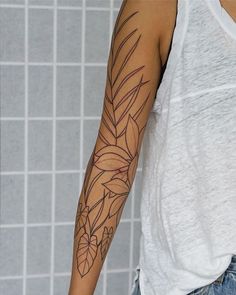 a person with a flower tattoo on their arm and shoulder is standing in front of a tiled wall