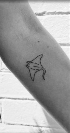 a black and white photo of a person's arm with a tattoo on it