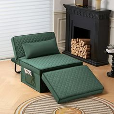 a green chair and ottoman in front of a fire place with logs on the floor