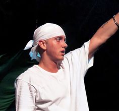 a man holding a tennis racquet on top of a tennis court with his arm in the air