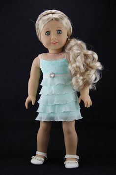 a doll with blonde hair wearing a blue dress