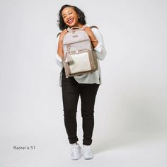 a woman with a backpack on her back is posing for the camera while she smiles