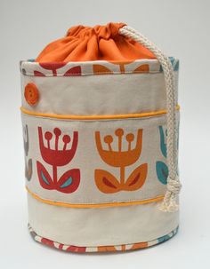 an orange drawstring bag sitting on top of a white table