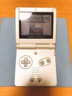 a nintendo wii game system sitting on top of a wooden table next to a blue cloth