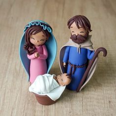 a figurine of a man and woman holding a baby jesus in a manger