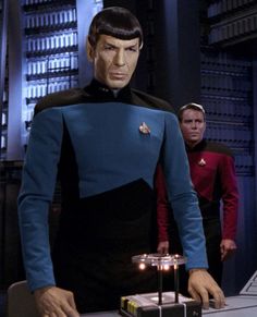 star trek's spock standing in front of a table with a cake on it