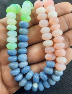 four different colored beads are held in someone's hand