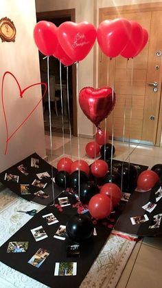 some red and black balloons in the shape of hearts on a table with other items