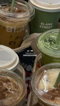 several iced drinks in plastic cups with straws