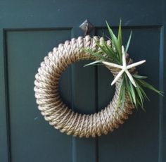 a close up of a rope wreath on a door with a starfish hanging from it