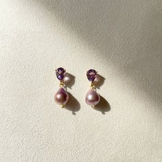 two-part Amethyst and pearl dangler. 
 - Encased teardrop shaped studs with purple-pink amorphous freshwater pearls. 
 - Size 1.25 approximately - 18k gold plated, brass 
 - Each order comes in a velvet pouch in our signature box, perfect for gifting Pink Teardrop Pearl Earrings For Formal Occasions, Elegant Purple Gemstone Pearl Earrings, Yellow Gold Teardrop Pearl Earrings With Gemstone, Purple Teardrop Pearl Drop Earrings, Gold Drop Pearl Earrings With Gemstones, Pear-shaped Amethyst Jewelry As Gift, Pear-shaped Gold Pearl Earrings With Gemstones, Purple Pearl Drop Jewelry, Elegant Amethyst Earrings As A Gift