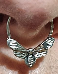 a close up of a person's ear with a butterfly on the back of it