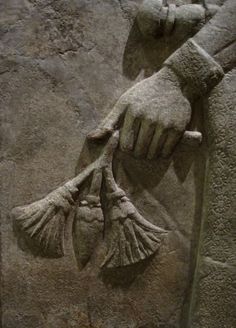 a stone carving of two hands holding fish tails