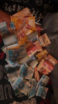 a pile of money sitting on top of a bed