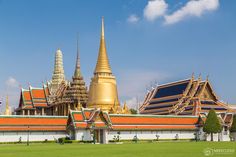 the large building has many spires on it's roof and is surrounded by green grass