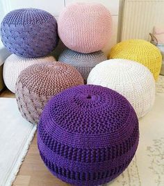 several knitted poufles sitting on the floor next to each other