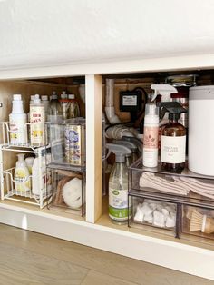 an organized kitchen cabinet filled with cleaning products