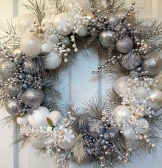 a christmas wreath with silver and white ornaments