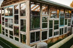 an old greenhouse with many windows and plants growing inside