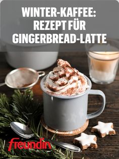 a cup of hot chocolate with whipped cream and cinnamon on top, surrounded by christmas decorations