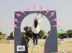 a woman standing on top of a chair in front of a mirror with pink arrows