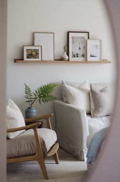 a living room filled with furniture and framed pictures