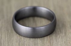 a close up of a wedding ring on a wooden table with wood grained background