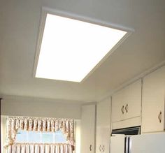 a kitchen with white cabinets and a skylight