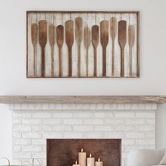 a living room with a fire place and wooden utensils on the mantle