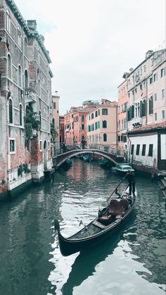 a gondola in the middle of a canal with buildings on both sides